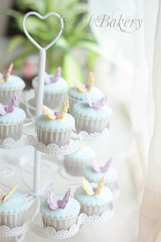 cupcakes are arranged in the shape of hearts on a cake stand with white doily