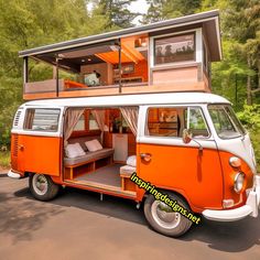 an orange and white vw bus parked in front of a house with a bed on top