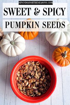 sweet and spicy pumpkin seeds in a red bowl on a white wooden table with mini pumpkins