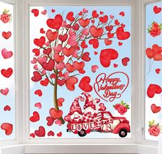 the window is decorated with hearts and a santa clause driving a red car in front of it