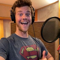 a man wearing headphones and making a funny face in front of a recording microphone