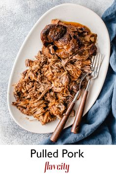 pulled pork on a white plate with two forks