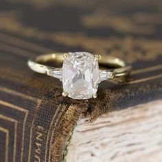 a close up of a ring on top of a book with a diamond in it