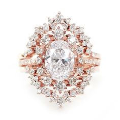 an oval cut diamond surrounded by smaller round diamonds in rose gold and white gold ring