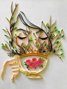 a woman's face is made out of paper with leaves and flowers on it