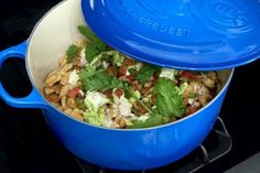 a blue pot filled with food sitting on top of a stove