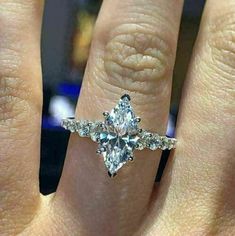 a woman's hand with a ring on it and a diamond in the middle