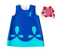 a blue dress with an image of a flower on the front and side, next to it