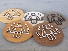 four wooden coasters with different symbols on them