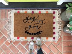 someone is standing in front of a door mat that says, yay it's you