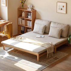 a bed sitting on top of a wooden floor next to a book shelf