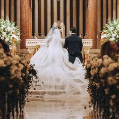 a bride and groom walking down the aisle at their wedding ceremony in an old church