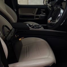 the interior of a vehicle with beige leather seats and steering wheel, center console area