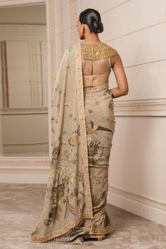 Gold floral printed saree in silk-crepe with hand-embroidered borders and crystal tassel detailing. Comes with closed-neck blouse with an elaborate hand-embroidered neckline and beadwork. Saree With Corset, Tarun Tahiliani Saree, Floral Print Saree, Saree Pallu, Floral Print Sarees, Print Saree, Nehru Jacket, Tarun Tahiliani, Printed Saree