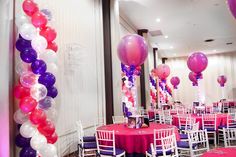 tables and chairs are set up for a party with pink, white and purple balloons