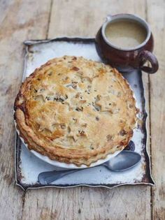 a pie sitting on top of a plate next to a cup of coffee