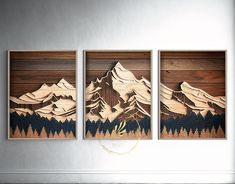 three pieces of wood with mountains and trees on them in a living room wall display