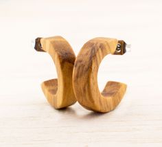 A pair of small wood hoop earrings / studs made of Olive wood. Please keep in mind when you're ordering that all products offered by us are being manufactured only after order placement for you in pure handicraft as special production and we do not have items in stock, so you can of course tell us which type of wood, sizes, etc.. SIZES Diameter approx. 16mm Wide approx. 4mm Thickness approx. 3mm DID YOU KNOW...? ♥ Each of your pieces of jewelry purchased from us comes lovingly packaged in a gift box. Ready to be given as a gift ;) ♥ To each pair of earrings we'll send you an alcohol pad to disinfect the pins again before you wear it! ♥ The wood from which your jewelry is made is 100% renewable! ♥ We use NO plastic for the packaging and shipping of your product! Everything is packaged in ec Wooden Round Earrings For Gifts, Wooden Round Earrings Gift, Brown Small Hoop Earrings As Gift, Wood Hoop Earrings, Earrings Wood, Wooden Hoop, Earrings Studs, Wood Sizes, Earrings Boho