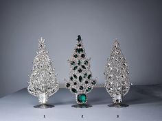 three different types of christmas trees with diamonds and emeralds on them, all in various shapes and sizes