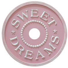 a pink sign that says sweet dreams on the front and back of it with white lettering