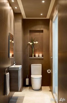 a bathroom with a toilet, sink and mirror in it's centerpieces