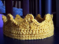 a crocheted yellow crown sitting on top of a table