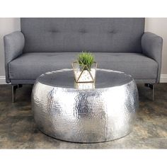 a living room with a gray couch and a silver coffee table on top of it