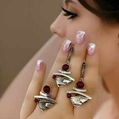 This exquisite Modern Contemporary Armenian Pomegranate Sterling Silver and Red Obsidian Jewelry Set, ideal for adding a touch of elegance to any occasion. The set includes a beautifully crafted ring and a pair of matching earrings, making it the perfect choice for Armenian-inspired gifts, weddings, or cocktail parties. Each piece in this set is a true work of art, meticulously handcrafted to reflect the rich symbolism of the Armenian pomegranate motif. The deep red hue of the Red Obsidian gemst Red Sterling Silver Jewelry Sets For Party, Red Sterling Silver Party Jewelry Sets, Red Jewelry Set For Anniversary, Red Jewelry Set With Matching Earrings For Anniversary, Elegant Red Metal Rings, Metal Jewelry Sets For Wedding, Elegant Red Jewelry Sets, Elegant Red Jewelry Sets With Matching Earrings, Burgundy Jewelry Set With Matching Earrings As Gift