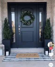 a front door with two potted plants and a welcome mat