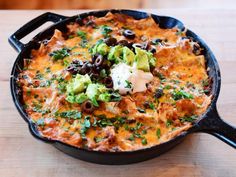 a skillet filled with black beans, tortilla shells and guacamole