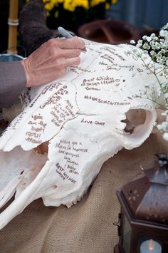 a person writing on a large animal skull