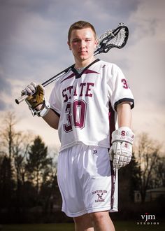 a man in white and maroon uniform holding a lacrosse stick