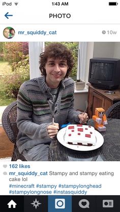 a man sitting at a table with a cake in front of him