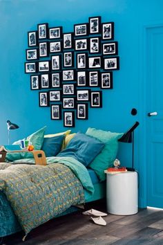 a bedroom with blue walls and pictures on the wall