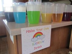 there are many cups on the counter with different colored drinks in them and a sign that says make your own rainbow drink