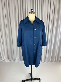 "Absolutely adorable blue vintage ladies raincoat made by Forecaster of Boston, Inc. in British Hong Kong. Shell is 100% woven polyester and lining is 100% Nylon Taffeta. Front patch pockets, ample collar, bands across wrists with button. All buttons intact and in excellent condition. Both functional and stylish! Inside tag says Size 18 but please refer to actual measurements below:  Back Shoulder Width: 18\"  Bust: 46\"  Waist: 44\"  Sleeve: 19\"  Back of neck to hem: 37\"  We always want you t Retro Blue Outerwear With Snap Buttons, Retro Blue Outerwear With Buttons, British Hong Kong, Vintage Plus Size, Raincoats For Women, Rain Coat, Back Shoulder, Blue Vintage, Hong Kong