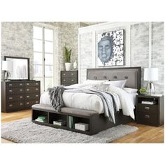 a bedroom with a bed, dressers and mirror in it's center area