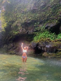 a woman standing in the water with her arms up