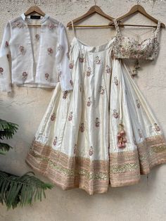 This beautiful ivory raw silk lehenga with mirror and thread handwork butti all over and heavy sequin pearl work border is paired with a light beige raw silk bustier with mirror, zardozi and thread zardozi work. This outfit is completed with an ivory organza jacket with mirror work. Lehenga With Mirror Work, Organza Jacket, Mirror Work Lehenga, Raw Silk Lehenga, Big Rangoli, Cape Fashion, Zardozi Work, Pearl Work, Lehenga Designs Simple