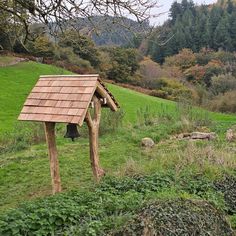 a small wooden structure in the middle of a field