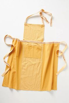 the apron is yellow and has two straps on it, which are tied to one side