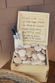 a wooden box filled with rocks and writing next to a basket full of pencils