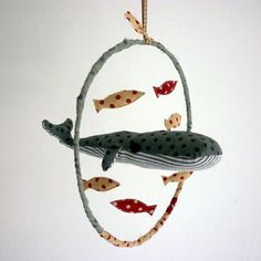 an ornament shaped like a whale with fish on it's tail hanging from a rope