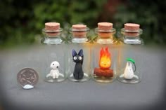 five miniature bottles with tiny figurines in them