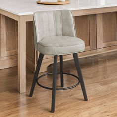 a white counter top sitting next to a bar stool with a wooden frame and metal legs