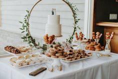 a table topped with lots of donuts and other desserts covered in frosting