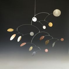 a wind chime with planets hanging from it's sides on a black background