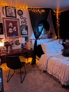 a bedroom decorated in black and white with pictures on the wall, lights strung from above