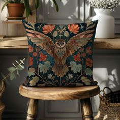 an owl pillow sitting on top of a wooden chair next to a potted plant