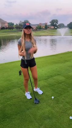 a woman standing on top of a green golf field